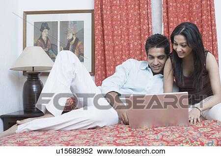 Young couple working on a laptop View Large Photo Image Stock Image - Young couple working on a laptop. Fotosearch