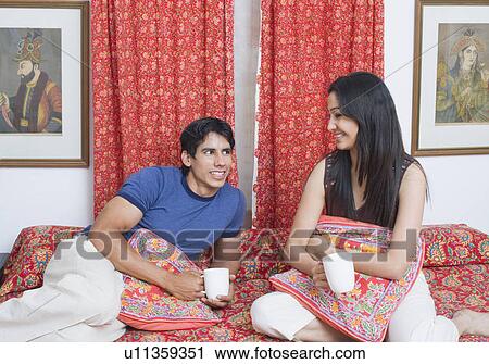 Young man looking at a young woman smiling View Large Photo Image Stock Image - Young man looking at a young woman smiling. Fotosearch