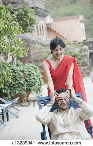 Young woman covering eyes of a young man from behind View Large Photo Image Stock Image - Young woman covering eyes of a young man from behind. Fotosearch