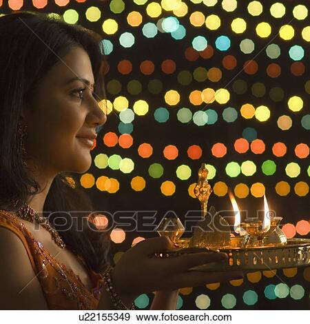 Stock Photo - Close-up of a young woman holding a diwali thali. Fotosearch