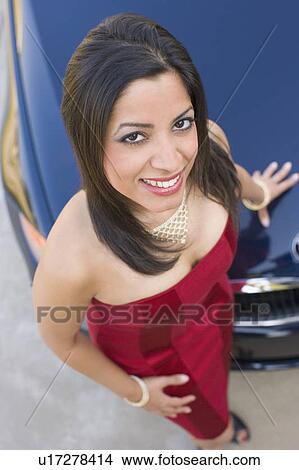 High angle view of a young woman smiling and standing near a car View Large Photo Image Picture - High angle view of a young woman smiling and standing near a car. Fotosearch
