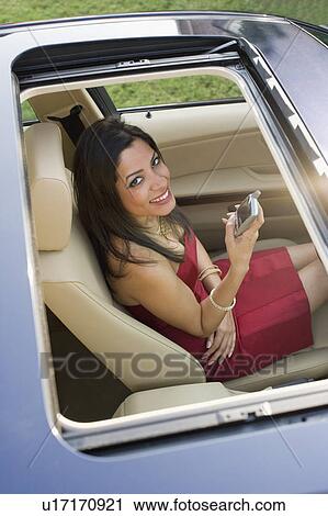 High angle view of a young woman sitting in a car View Large Photo Image Stock Image - High angle view of a young woman sitting in a car. Fotosearch