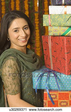 Portrait of a young woman holding gifts View Large Photo Image Stock Image - Portrait of a young woman holding gifts. Fotosearch