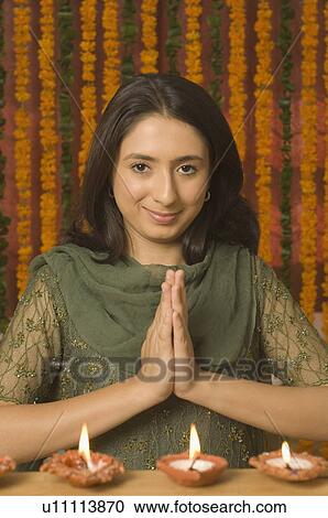 Stock Image - Portrait of a young woman praying on diwali. Fotosearch