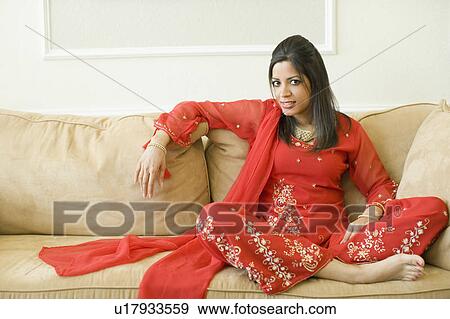 Stock Photo - Portrait of a young woman sitting on a couch. Fotosearch
