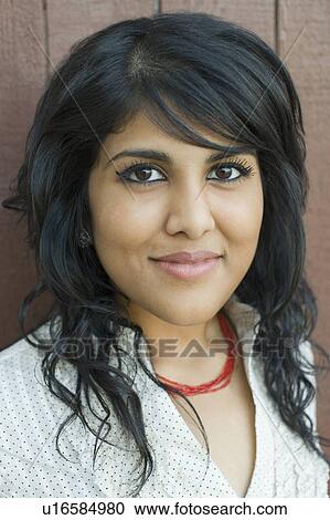 Stock Image - Portrait of a young woman smirking. Fotosearch