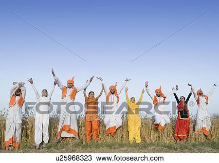 Stock Image - Four young couples jumping with their arms raised. Fotosearch