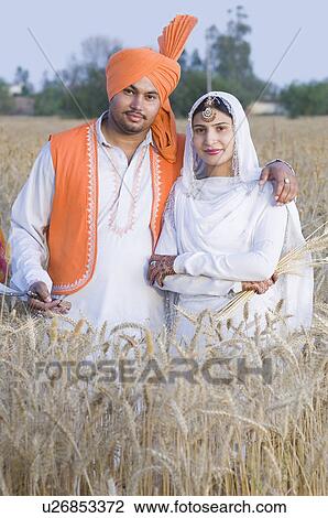 Portrait of a young couple standing in a wheat field View Large Photo Image Stock Image - Portrait of a young couple standing in a wheat field. Fotosearch