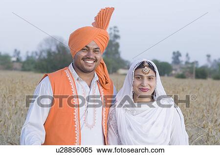 Portrait of a young couple standing in a wheat field and smiling View Large Photo Image Stock Photography - Portrait of a young couple standing in a wheat field and smiling. Fotosearch