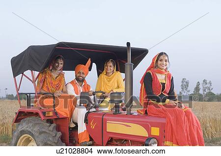 Portrait of a young man with three young women on a tractor View Large Photo Image Picture - Portrait of a young man with three young women on a tractor. Fotosearch