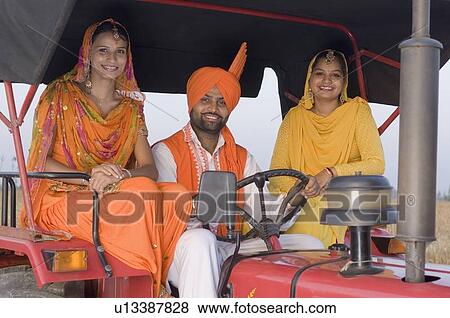Portrait of a young man with two young women on a tractor View Large Photo Image Stock Photo - Portrait of a young man with two young women on a tractor. Fotosearch