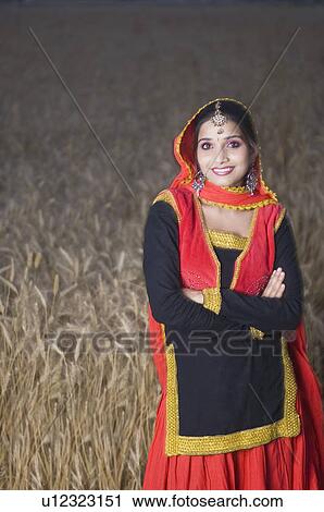 Portrait of a young woman standing in a wheat field and smiling View Large Photo Image Stock Image - Portrait of a young woman standing in a wheat field and smiling. Fotosearch