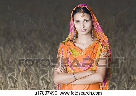 Portrait of a young woman standing in a wheat field View Large Photo Image Stock Image - Portrait of a young woman standing in a wheat field. Fotosearch