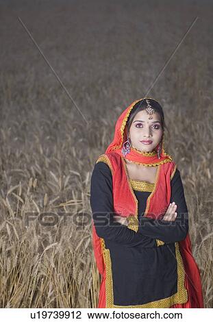 Portrait of a young woman standing in a wheat field View Large Photo Image Stock Image - Portrait of a young woman standing in a wheat field. Fotosearch
