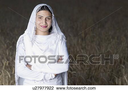 Portrait of a young woman standing in a wheat field View Large Photo Image Stock Image - Portrait of a young woman standing in a wheat field. Fotosearch