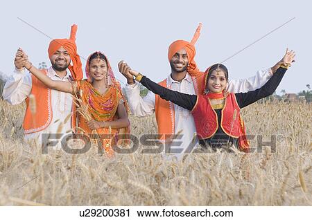 Stock Image - Portrait of two young couples dancing in a wheat field. Fotosearch