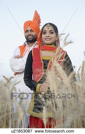 Young couple standing in a wheat field View Large Photo Image Stock Photo - Young couple standing in a wheat field. Fotosearch