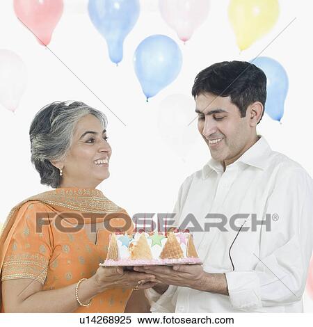 Stock Photography - Mature woman with her son holding a birthday cake. Fotosearch