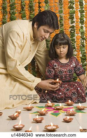Mid adult man and his daughter holding an oil lamp View Large Photo Image Stock Image - Mid adult man and his daughter holding an oil lamp. Fotosearch