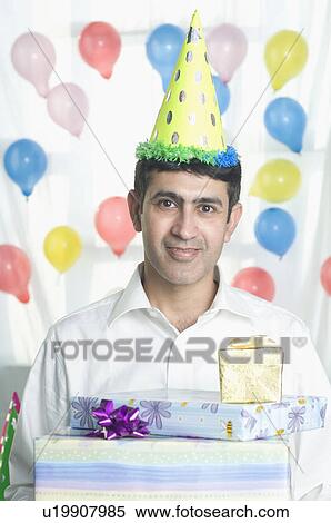 Mid adult man wearing a birthday hat and smiling View Large Photo Image Stock Photography - Mid adult man wearing a birthday hat and smiling. Fotosearch