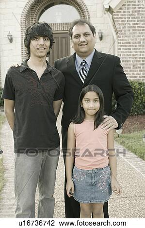 Stock Image - Portrait of a mature man standing with his son and daughter. Fotosearch