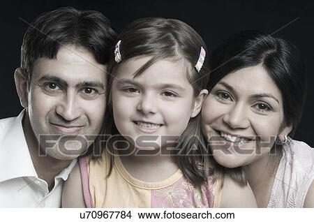 Portrait of a mid adult couple smiling with their daughter View Large Photo Image Picture - Portrait of a mid adult couple smiling with their daughter. Fotosearch