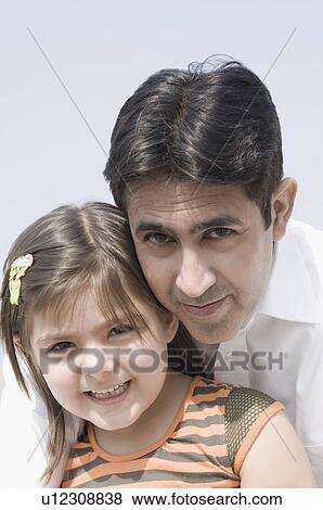 Portrait of a mid adult man smiling with his daughter View Large Photo Image Stock Photo - Portrait of a mid adult man smiling with his daughter. Fotosearch