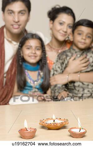 Portrait of a young couple sitting together with their son and daughter View Large Photo Image Picture - Portrait of a young couple sitting together with their son and daughter. Fotosearch