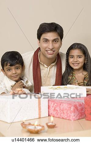 Young man smiling with his children View Large Photo Image Stock Photograph - Young man smiling with his children. Fotosearch