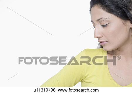 Close-up of a young woman thinking View Large Photo Image Stock Photo - Close-up of a young woman thinking. Fotosearch