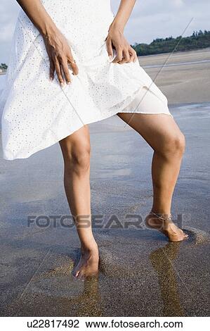Low section view of a woman standing on the beach View Large Photo Image Stock Image - Low section view of a woman standing on the beach. Fotosearch