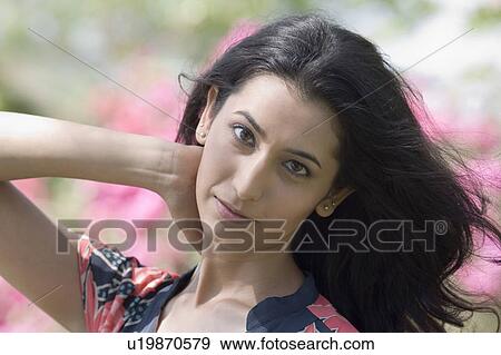 Portrait of a young woman with her hand in her hair View Large Photo Image Stock Photo - Portrait of a young woman with her hand in her hair. Fotosearch