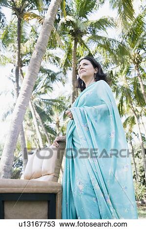 Side profile of a mature woman standing near an armchair View Large Photo Image Stock Image - Side profile of a mature woman standing near an armchair. Fotosearch