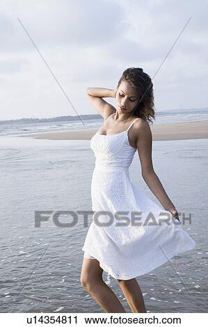 Side profile of a young woman standing on the beach View Large Photo Image Stock Image - Side profile of a young woman standing on the beach. Fotosearch