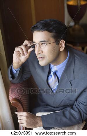 Businessman adjusting his eyeglasses View Large Photo Image Stock Image - Businessman adjusting his eyeglasses. Fotosearch