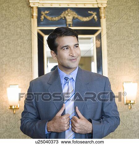 Businessman standing in a hotel and smirking View Large Photo Image Stock Image - Businessman standing in a hotel and smirking. Fotosearch