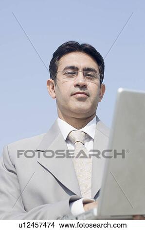 Picture - Close-up of a businessman working on a laptop. Fotosearch