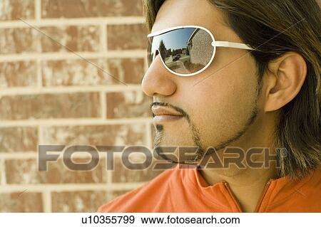 Close-up of a young man wearing sunglasses View Large Photo Image Stock Photo - Close-up of a young man wearing sunglasses. Fotosearch