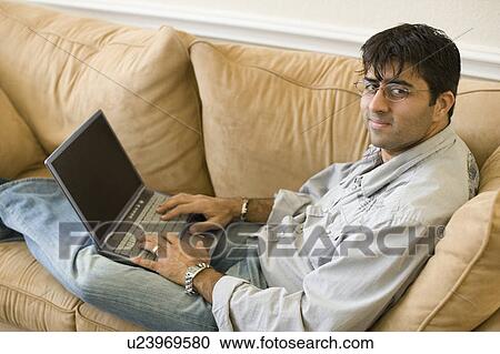 Stock Image - High angle view of a mid adult man working on a laptop. Fotosearch