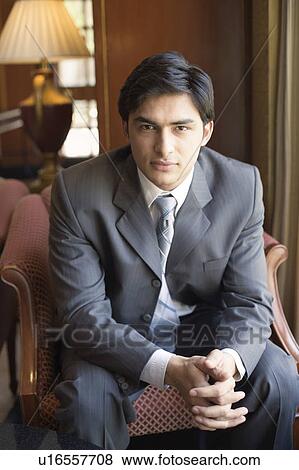 Portrait of a businessman sitting in an armchair with his hands clasped View Large Photo Image Stock Photo - Portrait of a businessman sitting in an armchair with his hands clasped. Fotosearch