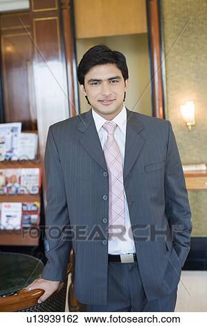 Portrait of a businessman standing with his hand in his pocket and smiling View Large Photo Image Stock Image - Portrait of a businessman standing with his hand in his pocket and smiling. Fotosearch