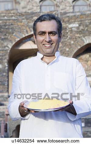 Portrait of a mid adult man holding a plate of powder paint and smiling View Large Photo Image Picture - Portrait of a mid adult man holding a plate of powder paint and smiling. Fotosearch