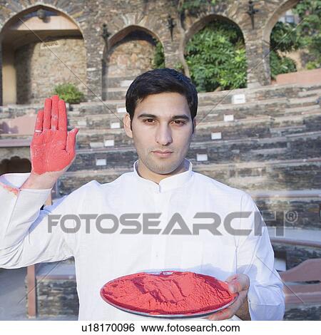 Portrait of a young man holding a plate of powder paint and showing his palm, Neemrana Fort Palace, Neemrana, Alwar, Rajasthan, India View Large Photo Image Stock Photograph - Portrait of a young man holding a plate of powder paint and showing his palm, Neemrana Fort Palace, Neemrana, Alwar, Rajasthan, India. Fotosearch