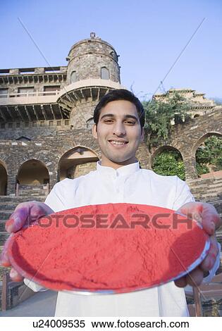 Portrait of a young man holding a plate of powder paint in front of a fort, Neemrana Fort Palace, Neemrana, Alwar, Rajasthan, India View Large Photo Image Stock Photography - Portrait of a young man holding a plate of powder paint in front of a fort, Neemrana Fort Palace, Neemrana, Alwar, Rajasthan, India. Fotosearch