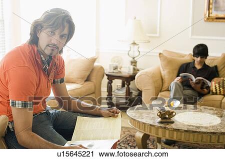 Portrait of a young man holding a magazine with his brother in the background View Large Photo Image Stock Image - Portrait of a young man holding a magazine with his brother in the background. Fotosearch