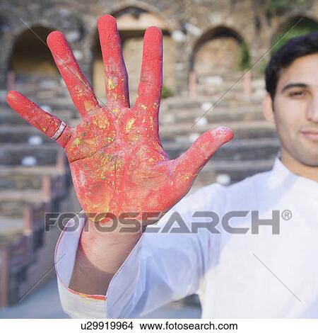 Picture - Portrait of a young man showing his hand with powder paint. Fotosearch