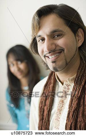 Portrait of a young man smiling with his sister in the background View Large Photo Image Stock Image - Portrait of a young man smiling with his sister in the background. Fotosearch