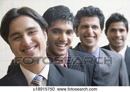 Stock Image - Portrait of four business executives smiling. Fotosearch
