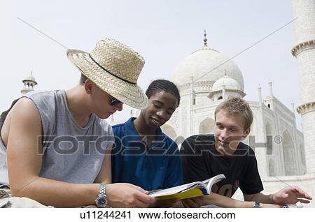 Three young men looking at a guidebook, Taj Mahal, Agra, Uttar Pradesh, India View Large Photo Image Stock Image - Three young men looking at a guidebook, Taj Mahal, Agra, Uttar Pradesh, India. Fotosearch