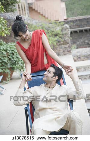 Stock Photography - Close-up of a young couple looking at each other and smiling. Fotosearch